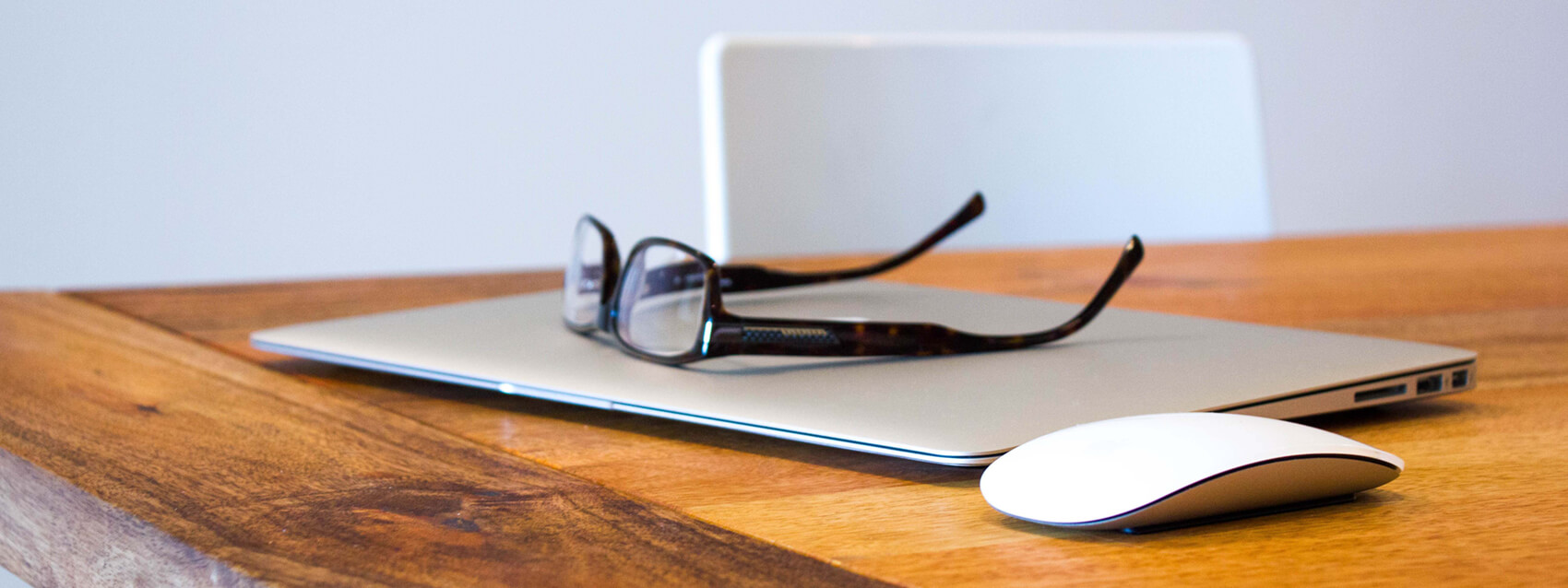 Glasses sit on top of closed modern laptop